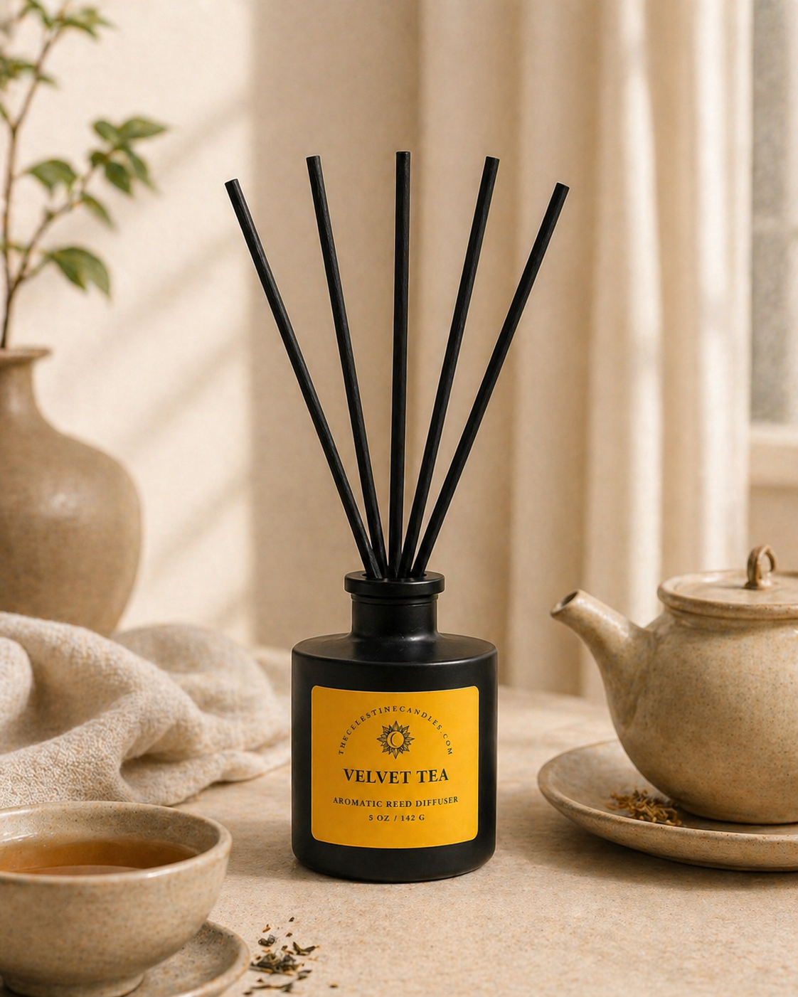 Diffuser with black reeds and yellow label on a table with tea-making items